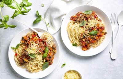 Twee borden gevuld met huisgemaakte spaghetti bolognaise. Afgewerkt met basilicumblaadjes die zorgen voor extra smaak en kleur in je bord. 