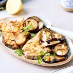 Een groot ovaal bord staat op tafel met de gebakken vismoten erop, samen met de gebakken aubergineschijfjes. De mosterpot van Tierenteyn staat er langs, samen met het gemaakt mosterdsausje. Het gerechtje werd afgewerkt met verse oreganoblaadjes. 