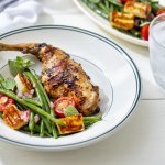 In het bord ligt een klaargemaakte bout, ze is heerlijk gegrild van op de BBQ. In het bordje zie je ook een groene bonensalade met tomaat en berloumikaas.  