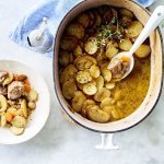 Stoofpotje met lamsvlees staat klaar op tafel om uit geschept te worden. Bovenop de stoofpot ligt een laagje krokante aardappelschijfjes. Deze stoofpot noemt men Lancashire hotpot. 