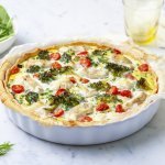 Het lijkt alsof de quiche net uit de oven komt. Ze staat nog ongesneden op het aanrecht klaar om aan te snijden en te smullen van deze hartige taart met broccoli, tomaatjes en schelvis.