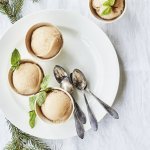 Drie sorbets staan op een wit rond bord, afgewerkt met een muntblaadje. De koffielepeltjes liggen ook op het witte bord, de tafel is aangekleed met takjes kerstboom.