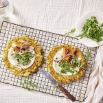 Op tafel ligt een rooster met hierop de courgettewraps. We serveren ze met een lepel kwark en mierikswortel, en daar boven op gerookte makreel stukjes en kappertjes. 