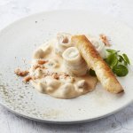 Op tafel staat een portie uitgeschept. Het roomsausje is lichtroze van kleur door de garnaaltjes. 