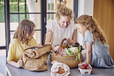 Mama en kinderen in keuken met boodschappen Mama en kinderen in keuken met boodschappen