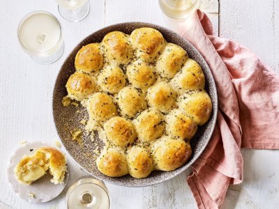 In het midden van de tafel vind je een groot rond keramiek bord in aardekleur. Hierin liggen de goudgele briochebroodjes met knoflookboter, en gevuld zijn met abdijkaas. Instant feestlook en heerlijk smaakvol als bijgerecht.  