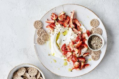Kaasdip met kruidige aardbeien Smeuïge kaasdip met kruidige aardbeien en crackers. Perfect zomers hapje om het aperitief mee te starten.