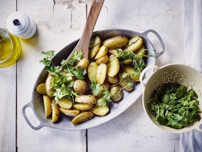 Krieltjes Krieltjes uit de oven in licht blauwe ovenschaal met verse kruiden, peper en zout.