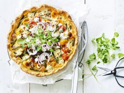 Quiche met boontjes, kerstomaat, lamsgehakt en geitenkaas Kleurrijke quiche gevuld met boontjes, kertomaat, geitenkaas en lamsgehakt. Ja, eentje met gehakt. We werken hem af met verse rode ui en waterkers. Ten aanval!