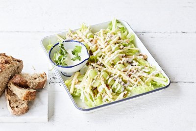 Een heerlijke Waldorfsalade van selder en groen appel. De frisse zurige vinaigrette zit in een apart potje en het brood in dikke sneden ligt er langs. 