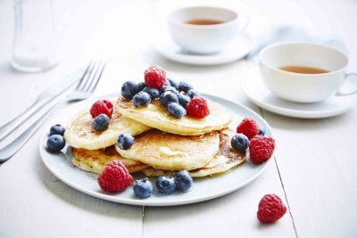 Pancakes met blauwe bessen, frambozen en honing