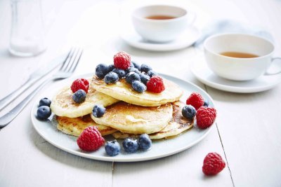 Pancakes met blauwe bessen, frambozen en honing Pancakes met blauwe bessen, frambozen en honing