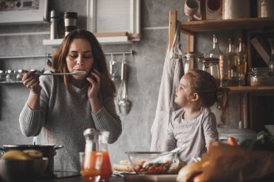 Vrouw met kind in de keuken Vrouw met kind in de keuken