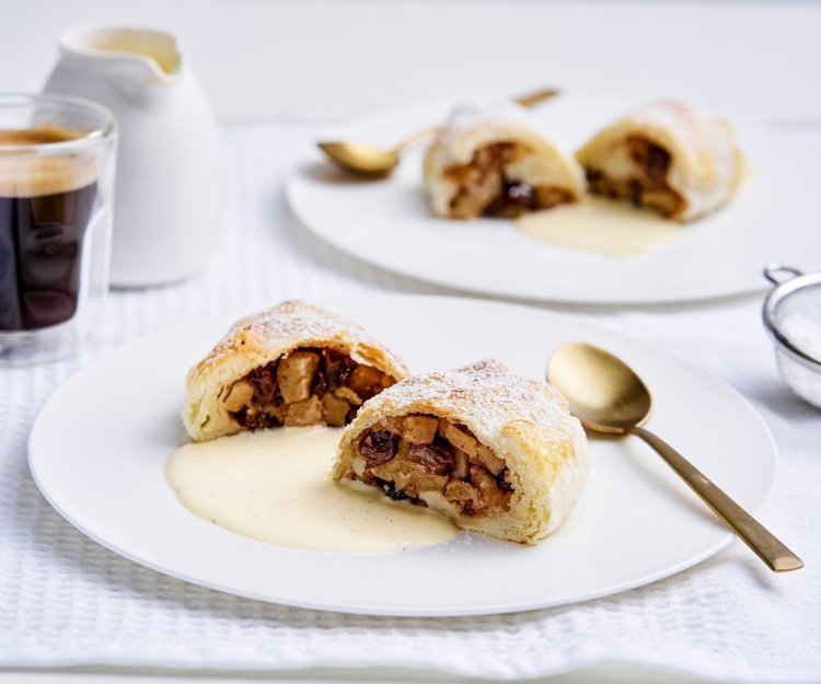Apfelstrudel met vanillesaus Op tafel staan twee bordjes met een hemels lekker dessert. Dit keer een appelstrudel of apfelstrudel zoals de echte, met een portie vanillesaus. Een koffie mag niet ontbreken.