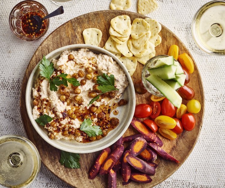 Dip van Brugge kaas, geroosterde kikkererwten en chilihoning Een heerlijke aperoplank staat op het midden van de tafel gevuld met een kaasdip, crackers, stukjes wortel en komkommer, kerstomaatjes en twee glaasjes wijn. Aanvallen zou ik zeggen.
