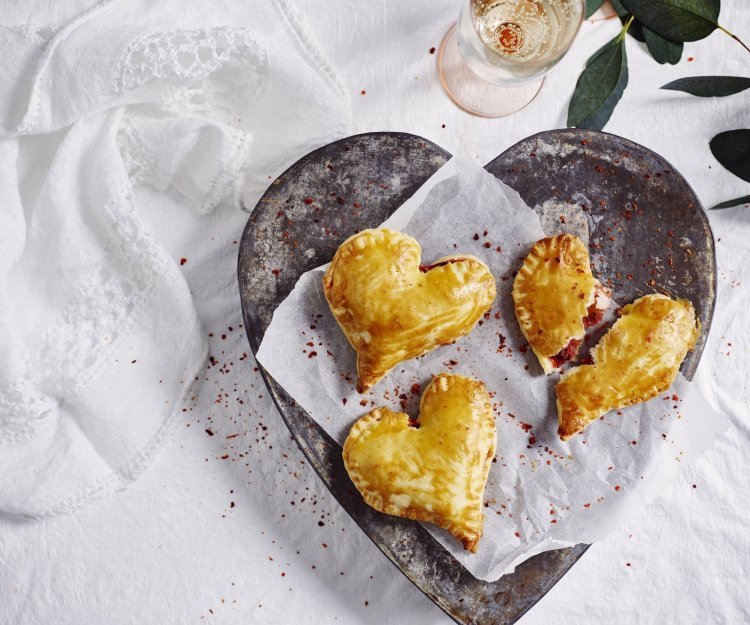 Empanadas met geitenkaas en rode biet Empanadas gemaakt in hartjesvorm liggen op een bordje te schitteren. Met dit hapje scoor je sowieso bij je geliefde.