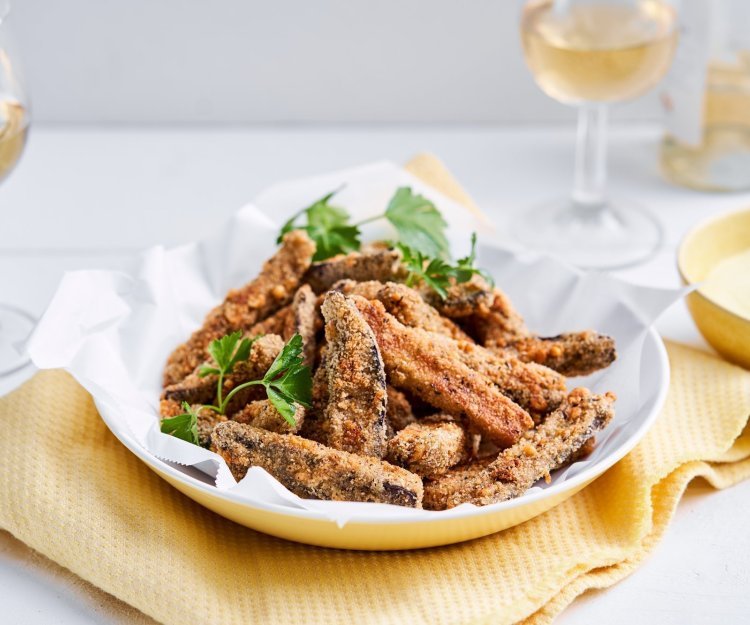 Frietjes van aubergine met currysausje Op de tafel staat een heerlijk krokant hapje van aubergine. Ja, krokante auberginefrietjes met een currydipsausje. Wij serveren hem met een glaasje rosé, ideaal als starter van heerlijke maaltijd.
