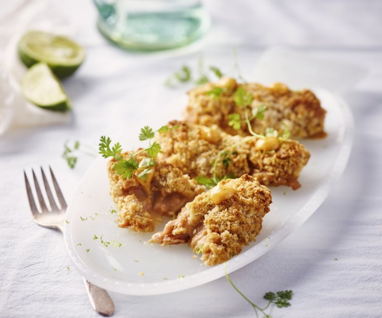 Garnaalkroketten uit de airfryer met chilimayonaise Heerlijke garnaalkroketten liggen op een ovaal wit bordje. Er liggen partjes limoen in de achtergrond en vorkje om meteen aan te vallen.