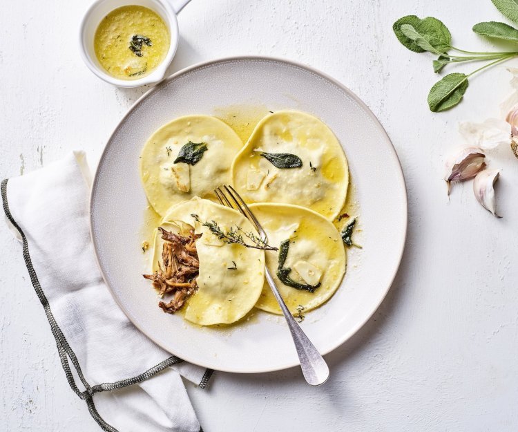 Gevulde ravioli van konijn met saliebotersaus Een heerlijk feestelijk bordje met homemade ravioli. Deze ravioli is gevuld met konijn en afgewerkt met een saliebotersausje en sinaasappel.