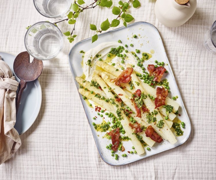 Hangop met asperge, erwtjes en spek Op tafel staat een groot rechthoekig bord met hierop het bijgerecht geserveerd. Het is een pareltje om naar te kijken, terwijl dit makkelijk en simpel te maken is.