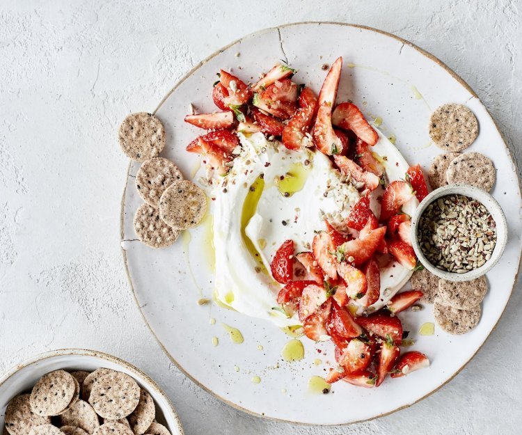 Kaasdip met kruidige aardbeien Smeuïge kaasdip met kruidige aardbeien en crackers. Perfect zomers hapje om het aperitief mee te starten.