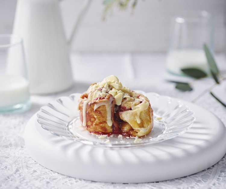 Mini kaneelbroodje met rood fruit zoals aardbei en framboos. Zomer in je broodje afgewerkt met gesmolten witte chocolade. Een tussendoortje om vingers en duimen van af te likken.