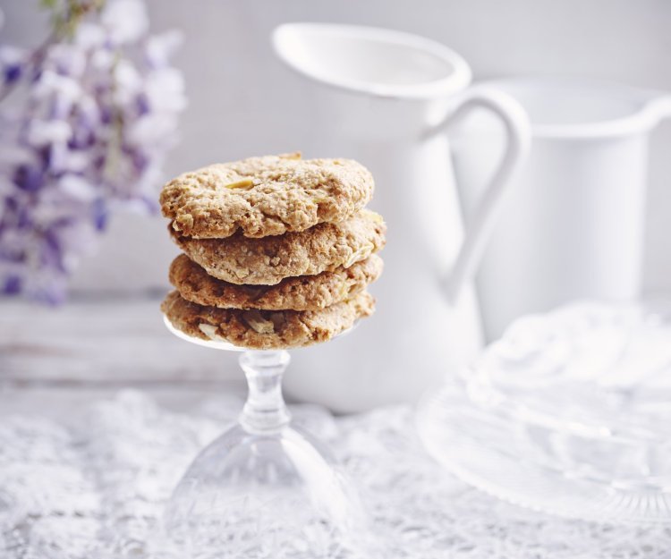 Heerlijke homemade cookies. Wij maakte er met appeltjes en pindakaas, een topcominatie. Ze liggen op de voet van een omgedraaid wijnglas. Achteraan de foto vind je een bloem van een Blauwe regen, melkkan en koffiekan. 