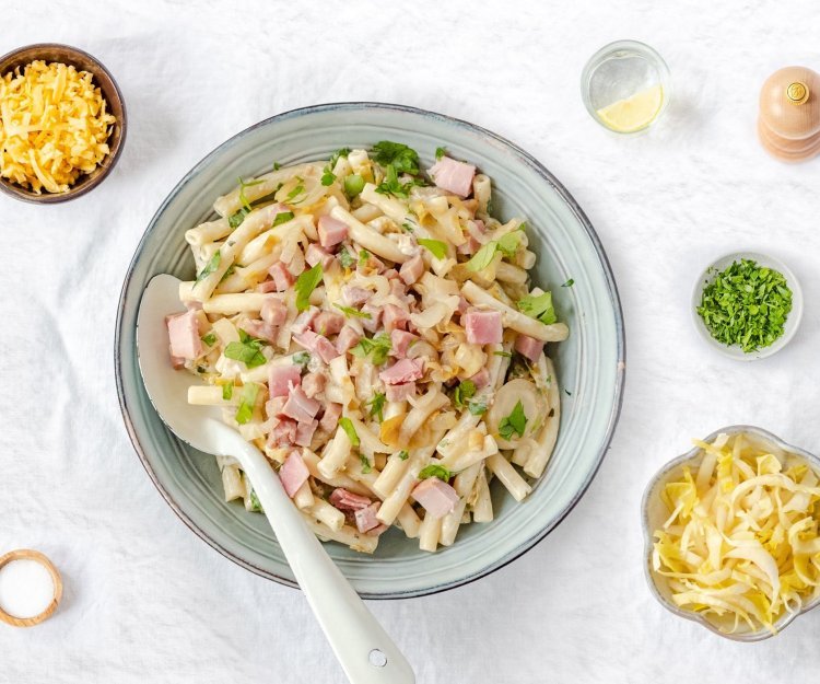 Macaroni met ham, roomkaas en witloof Macaroni met ham, roomkaas en witloof geserveerd in een diep bord.