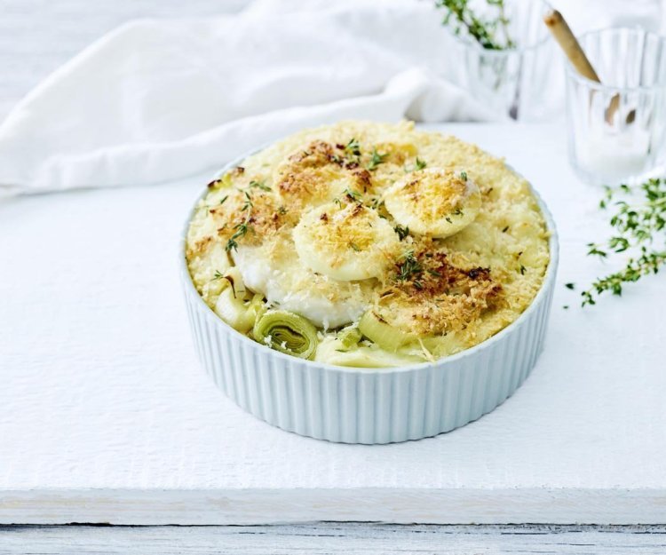 Ovenschotel met vis, prei, kaassaus en gekookte eieren Op het aanrecht staat een witte ronde ovenschotel met hierin alleen maar lekkers van eigen bodem. Denk maar aan puree met prei, witte vis, kaassaus en gekookte eieren. Een schotel zoals bij de bomma die iedereen lust. Oh, met kaaskorstje.
