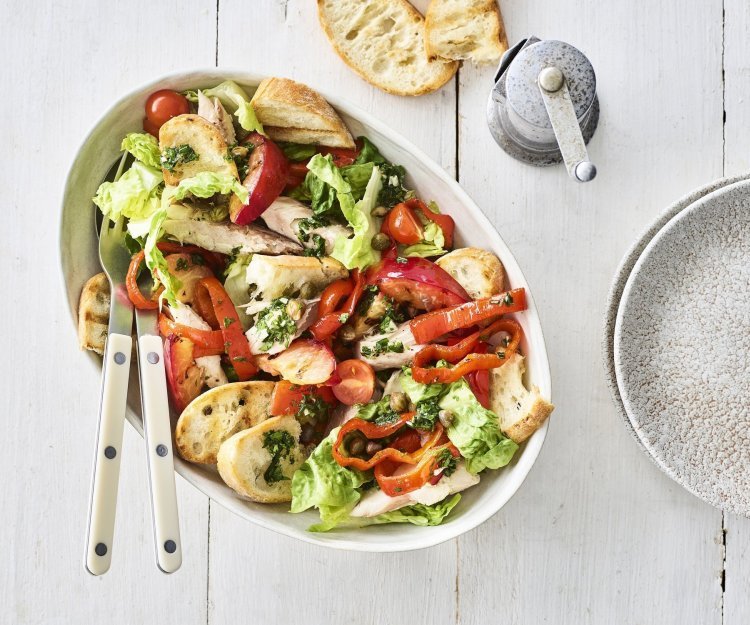 Panzanella met geroosterde paprika en gerookte makreel Op tafel staat een grote slakom met hierin de klaargemaakte panzanella op basis van geroosterde paprika, nectarine en gerookte makreel.