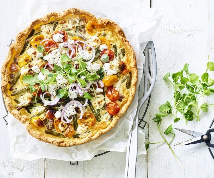 Kleurrijke quiche gevuld met boontjes, kertomaat, geitenkaas en lamsgehakt. Ja, eentje met gehakt. We werken hem af met verse rode ui en waterkers. Ten aanval! 