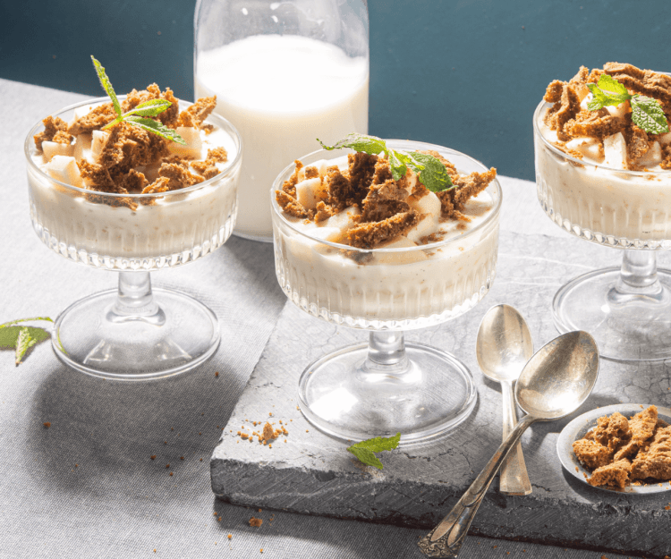 Rijstpap met appel en bastognekoekjes Rijstpap geserveerd in mooie champagnecoupes zorgen instant voor een dessert met sterallures. Hij kreeg een topping mee van appelblokjes en bastognekoekjes voor een crunch. Er zijn 3 glaasjes in beeld.