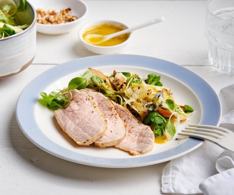 Salade met varkensgebraad en mosterddressing Er staat een bordje op tafel, gevuld met de kleurrijke én rijke salade. Er liggen ook enkele sneetjes varkensgebraad bij. Je kan extra salade scheppen en vinaigrette.