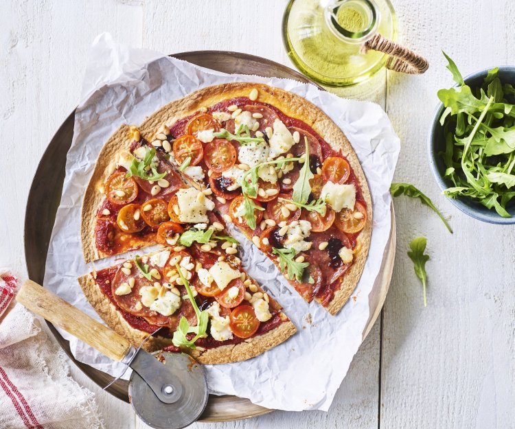 Snelle pizza-tortilla Een snelle pizza op tafelen toveren doe je met deze tortizza. De pizzabodem maakten we van een tortilla waar we lekkers aan toevoegde. Denk maar aan tomaatjes, salami en geitenkaas. We voegden ook nog een handje rucola toe voor de kleur. De pizza ligt al aangesneden op een groot bord.