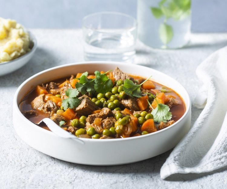 Stew met rundsvlees, erwtjes en worteltjes Libanes stoofpot staat klaar op tafel. Een stew van biefstuk, erwtjes en worteltjes. Wij serveren hem met een kommetje puree.