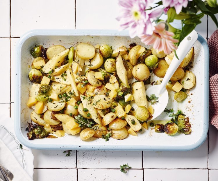 Traybake met aardappelen, spruitjes, pastinaak en brokkelkaas Een heerlijk geurende ovenschotel staat op het aanrecht. Het is een traybake van aardappelen met spruitjes, pastinaak en Beauvoordse brokkelkaas.
