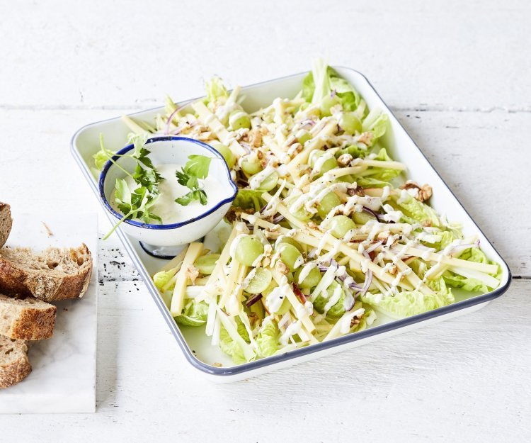 Een heerlijke Waldorfsalade van selder en groen appel. De frisse zurige vinaigrette zit in een apart potje en het brood in dikke sneden ligt er langs. 