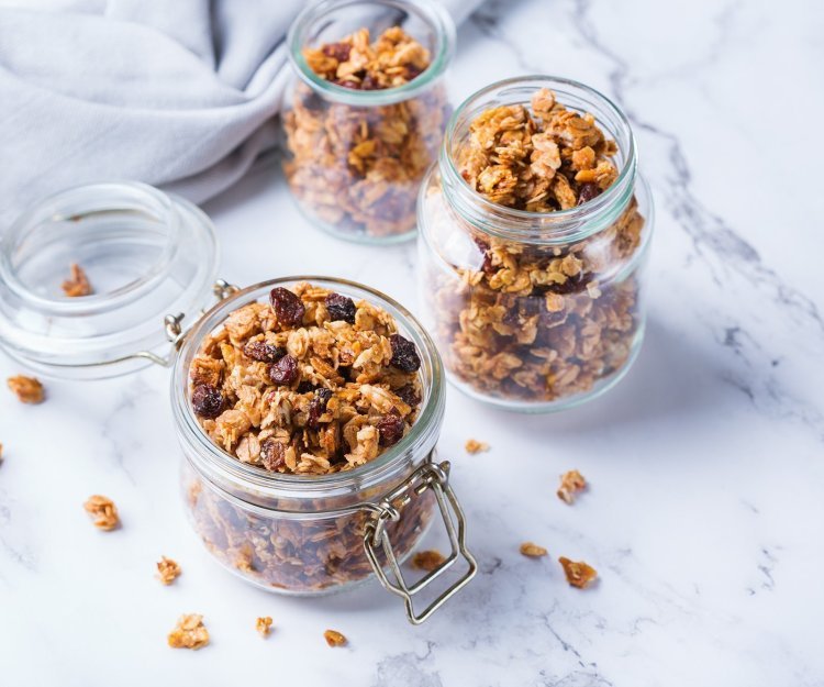 Homemade granola in 2 bokalen op het marmere aanrecht. 