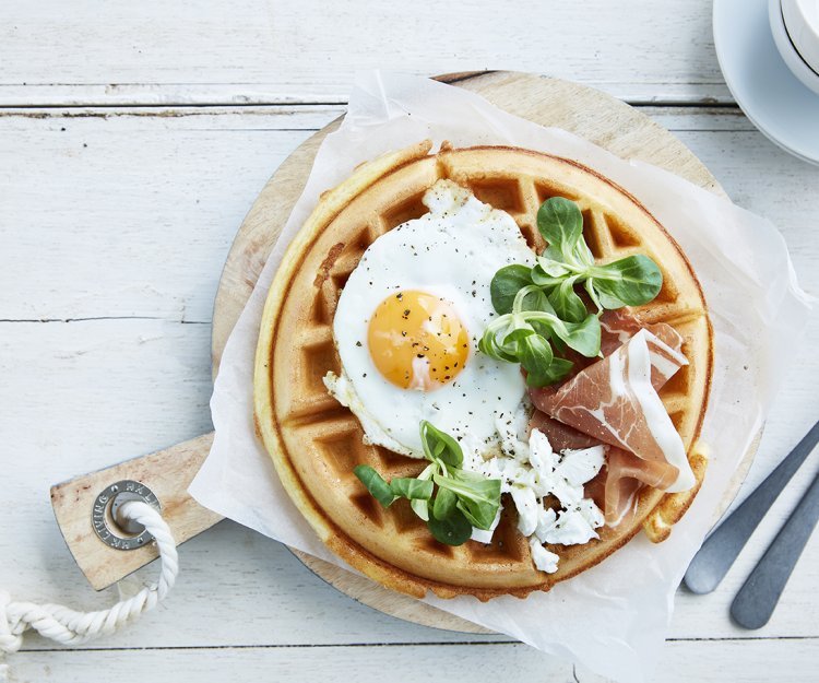 Ontbijtwafel met spiegeleitje, gedroogde ham en geitenkaas