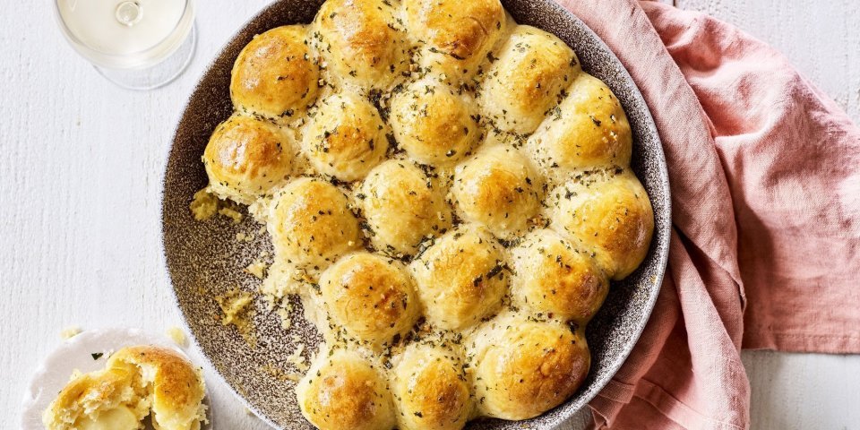 Briochebroodjes gevuld met abdijkaas en knoflookboter In het midden van de tafel vind je een groot rond keramiek bord in aardekleur. Hierin liggen de goudgele briochebroodjes met knoflookboter, en gevuld zijn met abdijkaas. Instant feestlook en heerlijk smaakvol als bijgerecht.