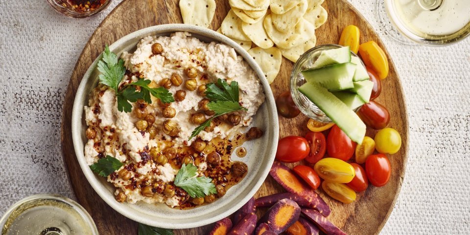 Dip van Brugge kaas, geroosterde kikkererwten en chilihoning Een heerlijke aperoplank staat op het midden van de tafel gevuld met een kaasdip, crackers, stukjes wortel en komkommer, kerstomaatjes en twee glaasjes wijn. Aanvallen zou ik zeggen.