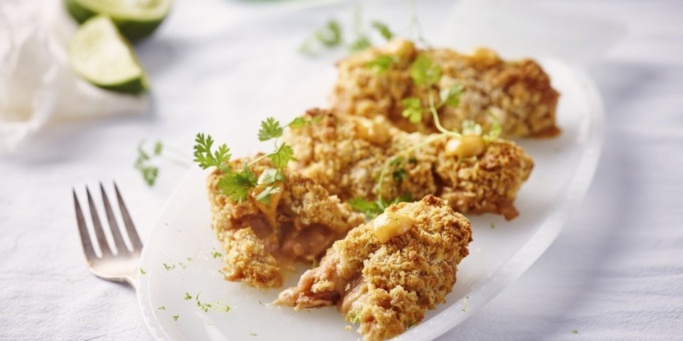 Garnaalkroketten uit de airfryer met chilimayonaise Heerlijke garnaalkroketten liggen op een ovaal wit bordje. Er liggen partjes limoen in de achtergrond en vorkje om meteen aan te vallen.