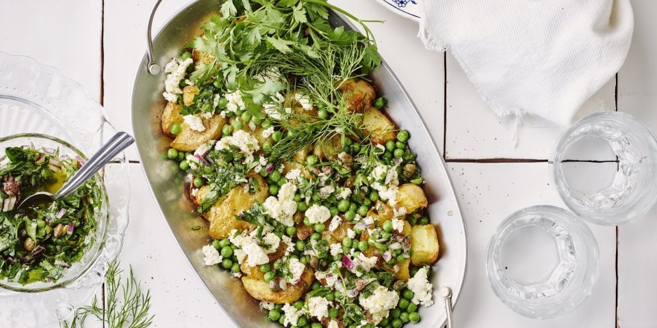 De gebakken patattjes staan op het midden van de tafel, er staan twee glazen water langs en een schaaltje met de salsa verde. 