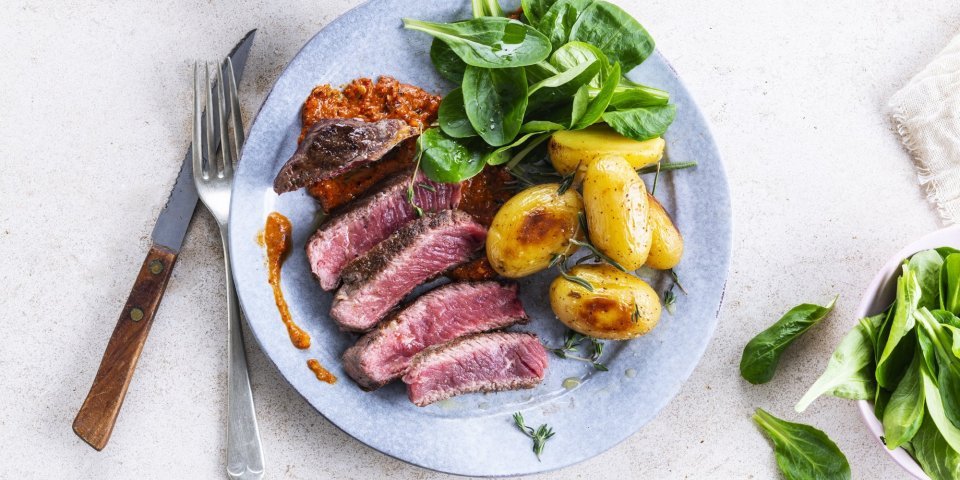Gegrilde steak met romescosaus en gepofte krieltjes Gegrilde steak met romescosaus en gepofte krieltjes