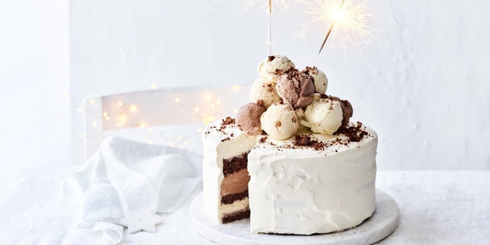 IJstaart van chocolade, gezouten karamel en vanille Een prachtige laagjestaart opgebouwd uit chocolade biscuit, vanille-ijs, karamelijs en chocolade-ijs. De taart kreeg een witte afwerkingslaag aan de buitenkant en aan de bovenzijde liggen verschillende bollen ijs. Als afsluiter werden er sterrenstokjes aangestoken bovenop de taart.