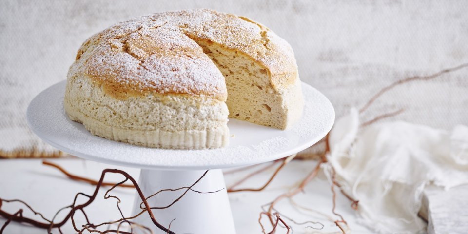 Japanse cheesecake Een Japanse cheesecake, ook wel cheescakesoufflé genoemd, staat op een taartstandaard. Er is al 1 stukje aangesneden om meteen te smullen.