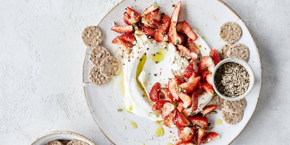 Kaasdip met kruidige aardbeien Smeuïge kaasdip met kruidige aardbeien en crackers. Perfect zomers hapje om het aperitief mee te starten.