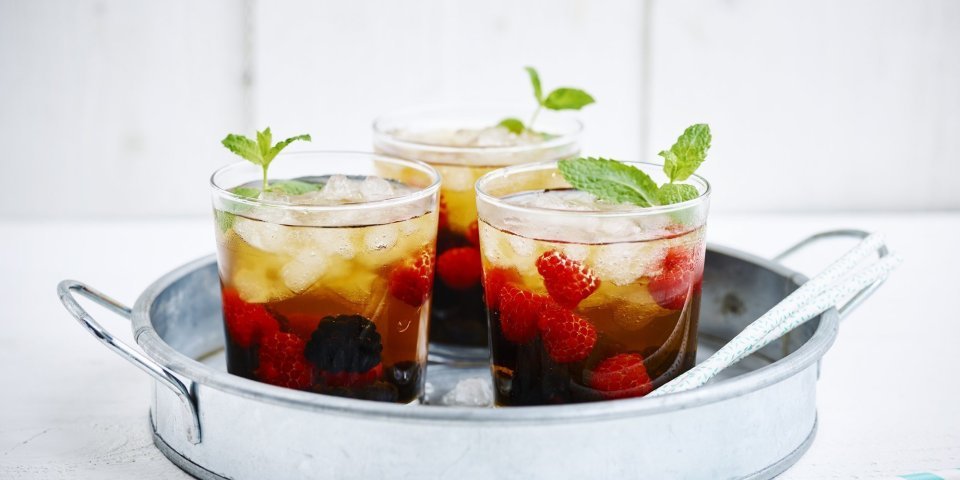 Mocktea van rood fruit Een homemade mocktea van rood zomerfruit. Gepresenteerd in glaze theeglaasjes op een inox dienblad, klaar om te brengen naar de gasten en aan te vallen.