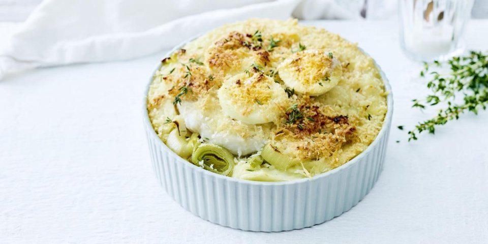 Ovenschotel met vis, prei, kaassaus en gekookte eieren Op het aanrecht staat een witte ronde ovenschotel met hierin alleen maar lekkers van eigen bodem. Denk maar aan puree met prei, witte vis, kaassaus en gekookte eieren. Een schotel zoals bij de bomma die iedereen lust. Oh, met kaaskorstje.