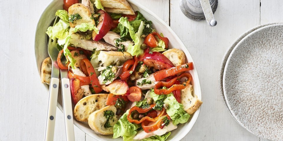 Panzanella met geroosterde paprika en gerookte makreel Op tafel staat een grote slakom met hierin de klaargemaakte panzanella op basis van geroosterde paprika, nectarine en gerookte makreel.